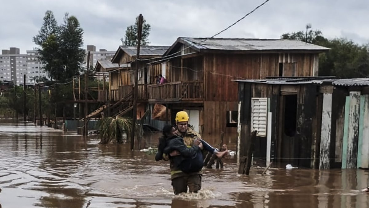 Un bombero rescata a uno de los afectados por las fuertes lluvias, en Passo Fundo.