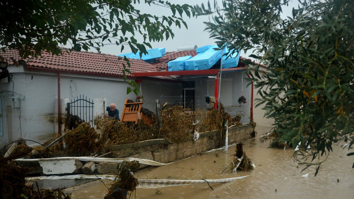 un hombre intenta limpiar el barro del patio de su casa en la aldea de Nees Karies, cerca de Larissa, Tesalia, Grecia central, 06 de septiembre de 2023.
