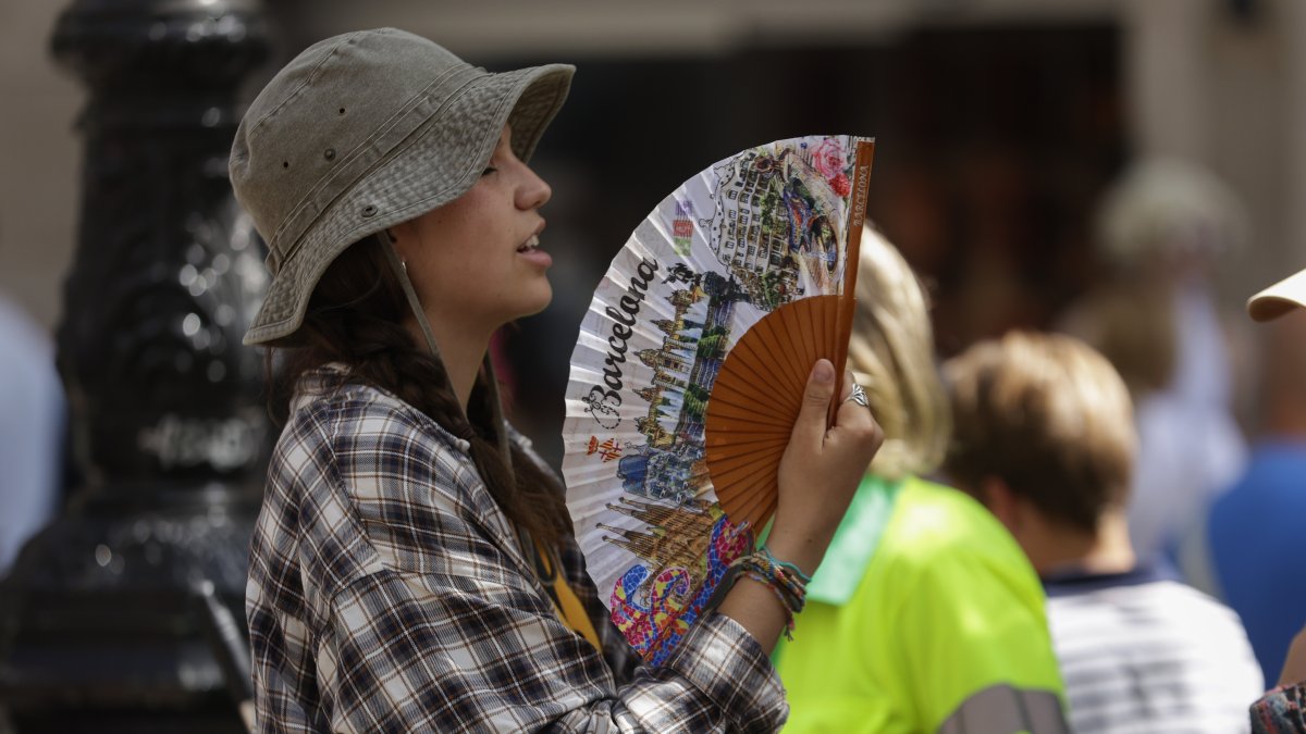 Una turista intenta refrescarse con un abanico en el centro de Barcelona, el pasado mes de julio