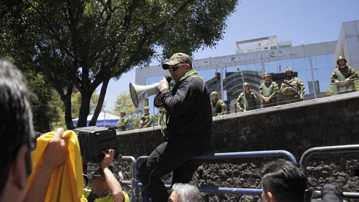 Afuera del CNE, en Quito, decenas de personas pedían la renuncia de los vocales electorales.