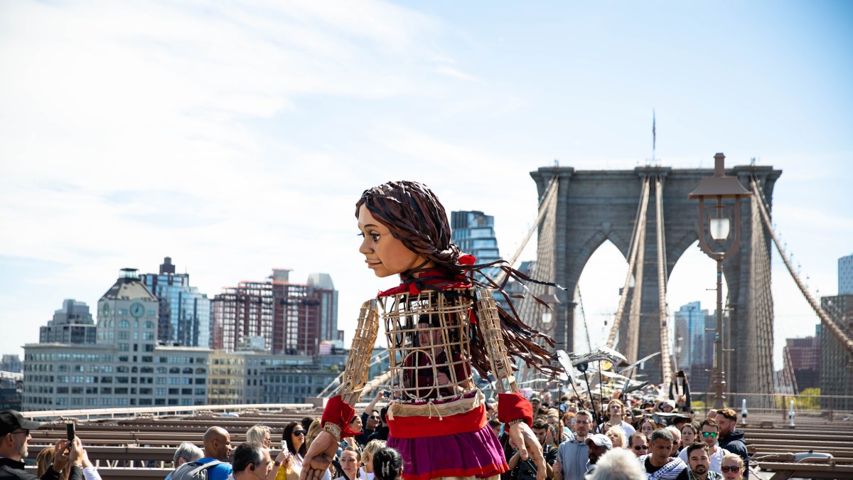 Amal, es una marioneta de 3,6 metros de altura que representa a una niña siria refugiada de 10 años que dejó su país en busca de su madre que emigró hacia el Reino Unido.