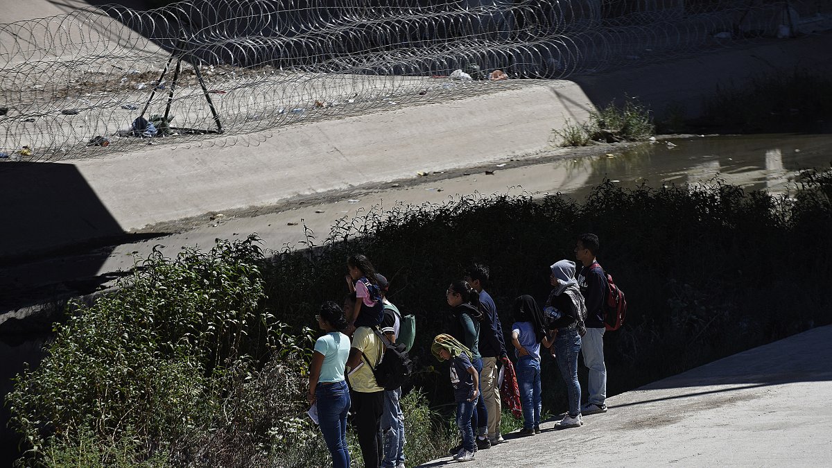 Un grupo de migrantes camina a un costado del río Bravo, frontera natural entre México y EE.UU., en Ciudad Juárez, Chihuahua (México).