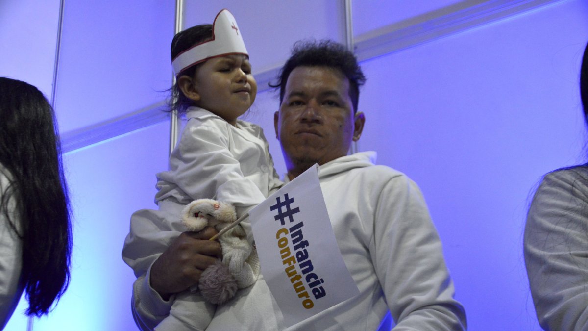 Un padre y su bebe participan en la presentación de los resultados del programa Infancia con Futuro, el 5 de septiembre en Quito.