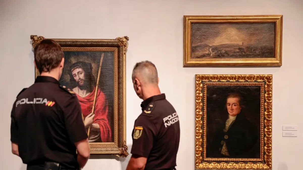 Agentes contemplan tres de las cinco obras de arte falsas
