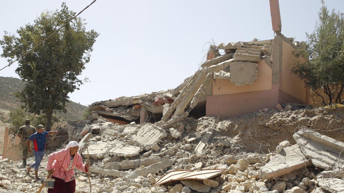 Varias personas caminan entre los escombros en la aldea de Tafagajt, en Marruecos.