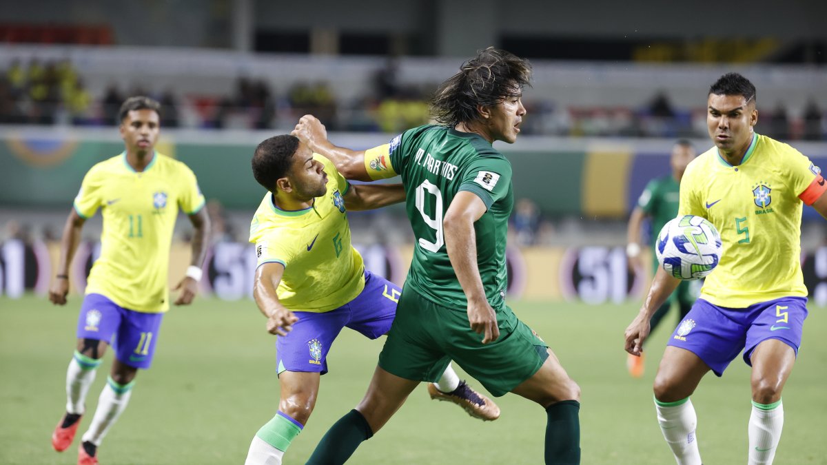 Renan Lodi (i), de Brasil, disputa el balón con Marcelo Martins (c), de Bolivia.