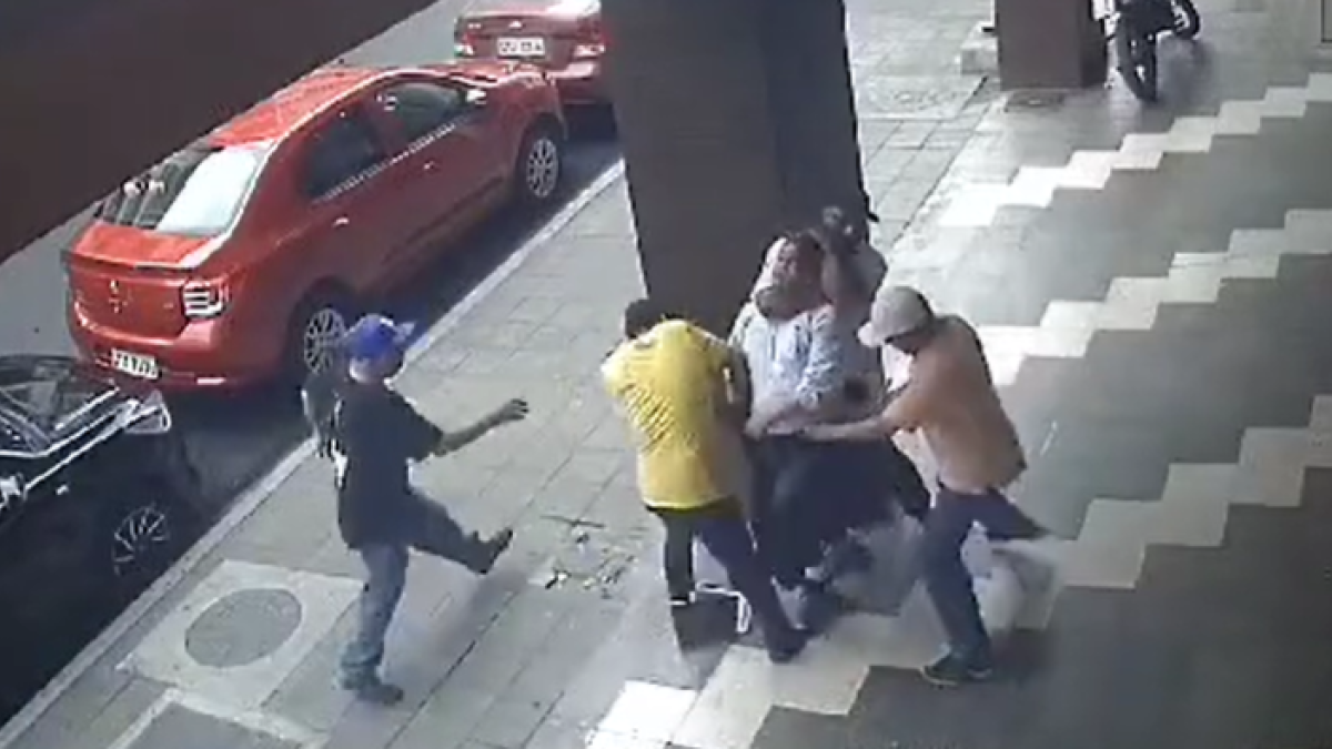 Tres de los delincuentes le arrebatan todas las pertenencias al ciudadano, mientras un cuarto lo mantiene inmóvil desde el cuello.