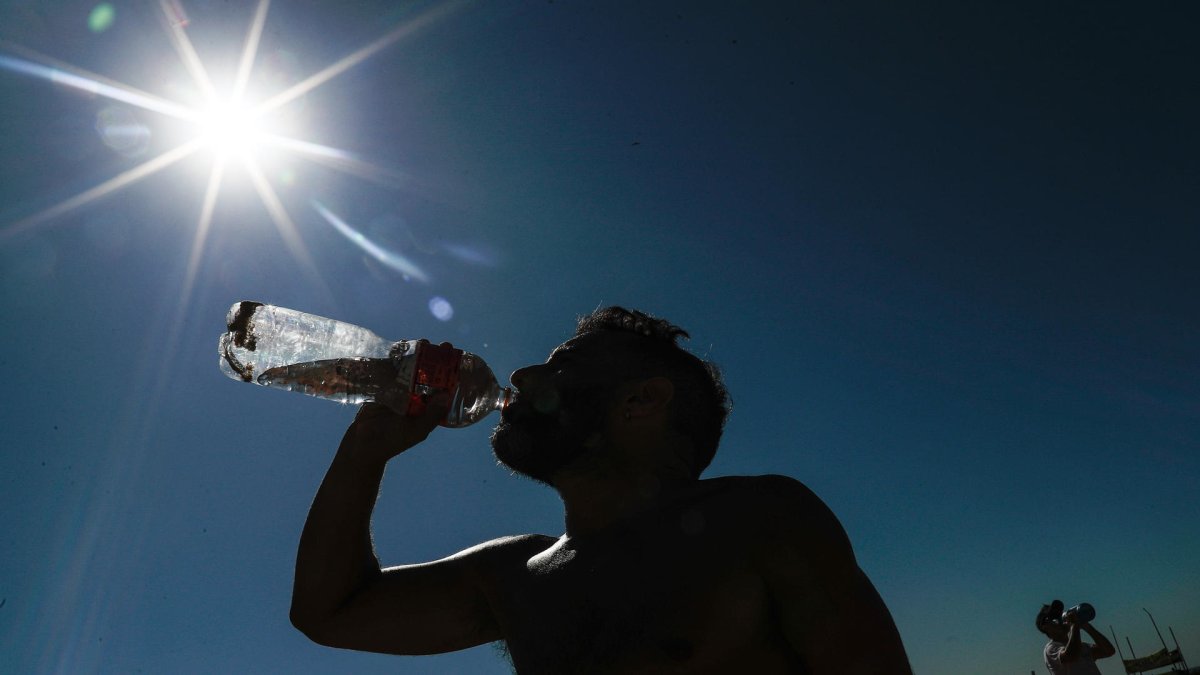 Un hombre bebe agua durante el descanso de una actividad física este 19 de septiembre de 2023 en la playa de Copacabana, en Río de Janeiro.