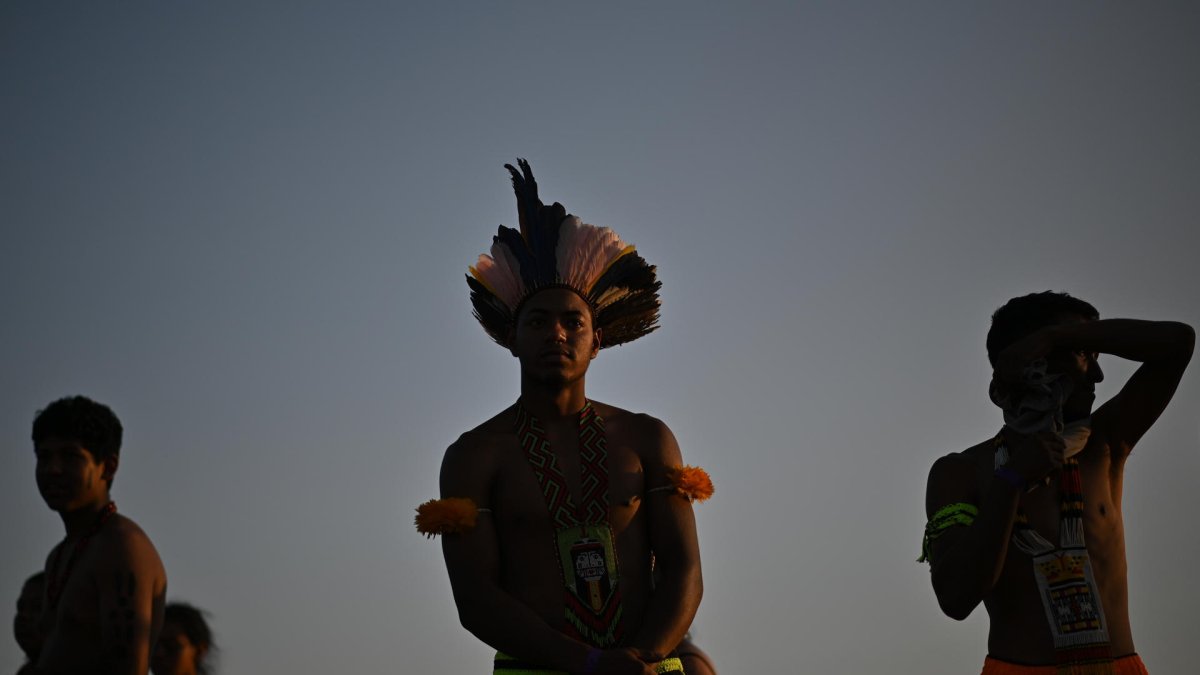 Indígenas observan este miércoles la transmisión del juicio sobre el marco temporal en una pantalla gigante instalada frente al Supremo Tribunal Federal, en Brasilia.
