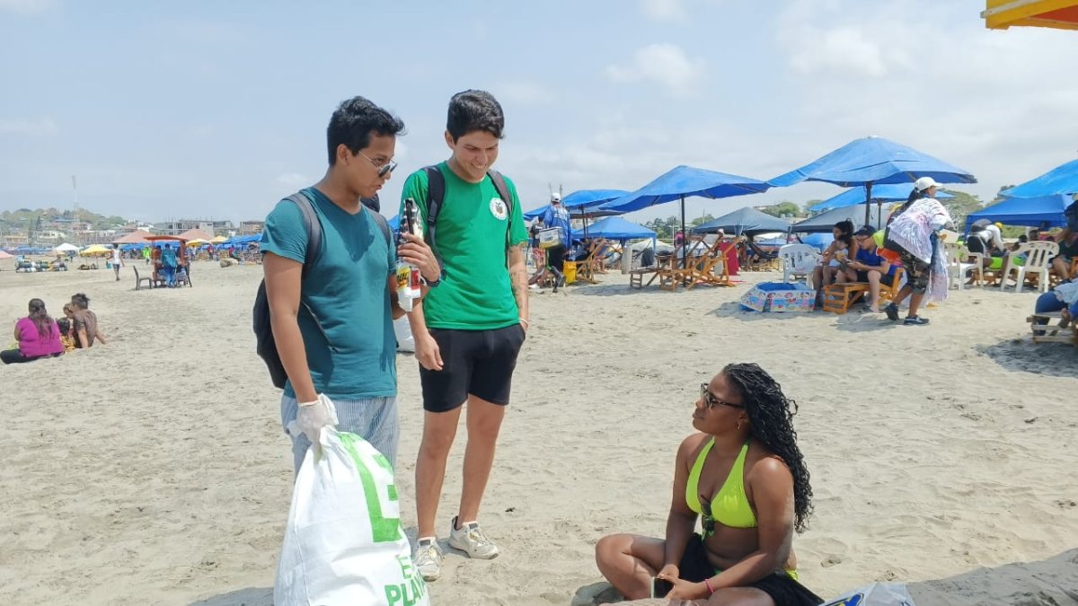 Los estudiantes dialogan con los turistas sobre la importancia de mantener limpias las playas.