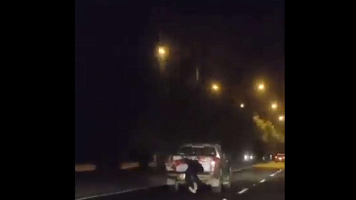 En la imagen se observa como el sujeto, a pesar del riesgo de ser atropellado, se agarra del carro para robar los paquetes.