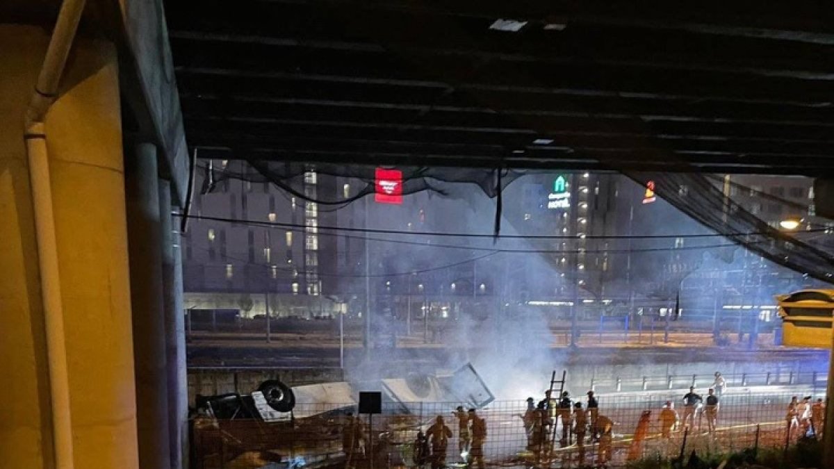 El autobús cayó por la pasarela, que cruzaba la autopista, y tras un vuelo de diez metros cayó entre un almacén y las vías del tren, según las primeras versiones.