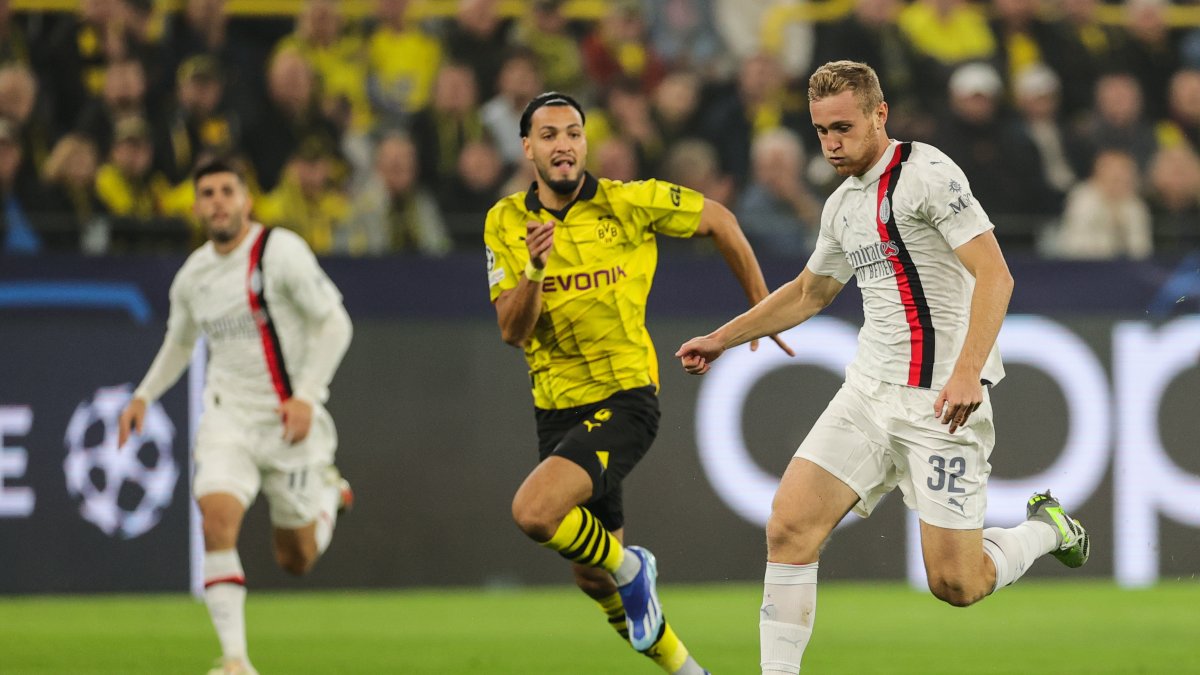 Ramy Bensebaini (i) de Dortmund y Tommaso Pobega (d) de Milán en acción durante el partido del Grupo F de la Liga de Campeones de la UEFA entre Borussia Dortmund y el AC Milan en Dortmund.