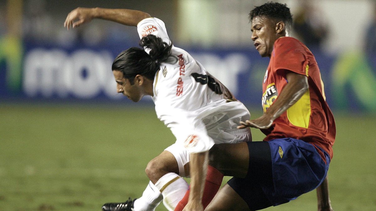 Fotografía de archivo, tomada en abril de 2007, en la que se registró al exfutbolista Rolan De La Cruz (d), al actuar para el equipo colombiano Deportivo Pasto, durante el partido por la Copa Libertadores, en Santos Brasil.