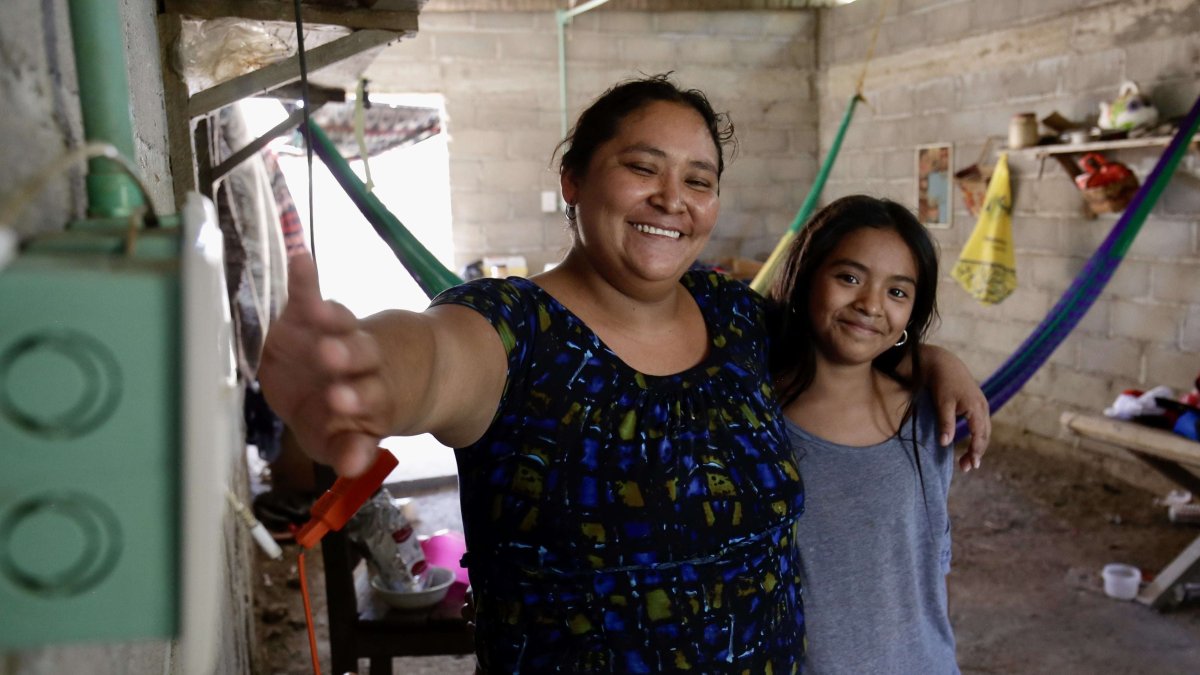 Oaxaca. Una mujer mientras enciende un interruptor, la luz le da vida.