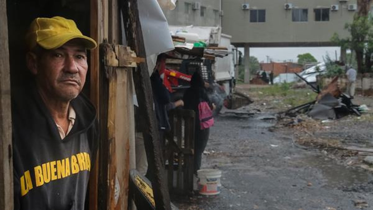 Un hombre observa los restos de las casas quemadas, en Asunción (Paraguay)