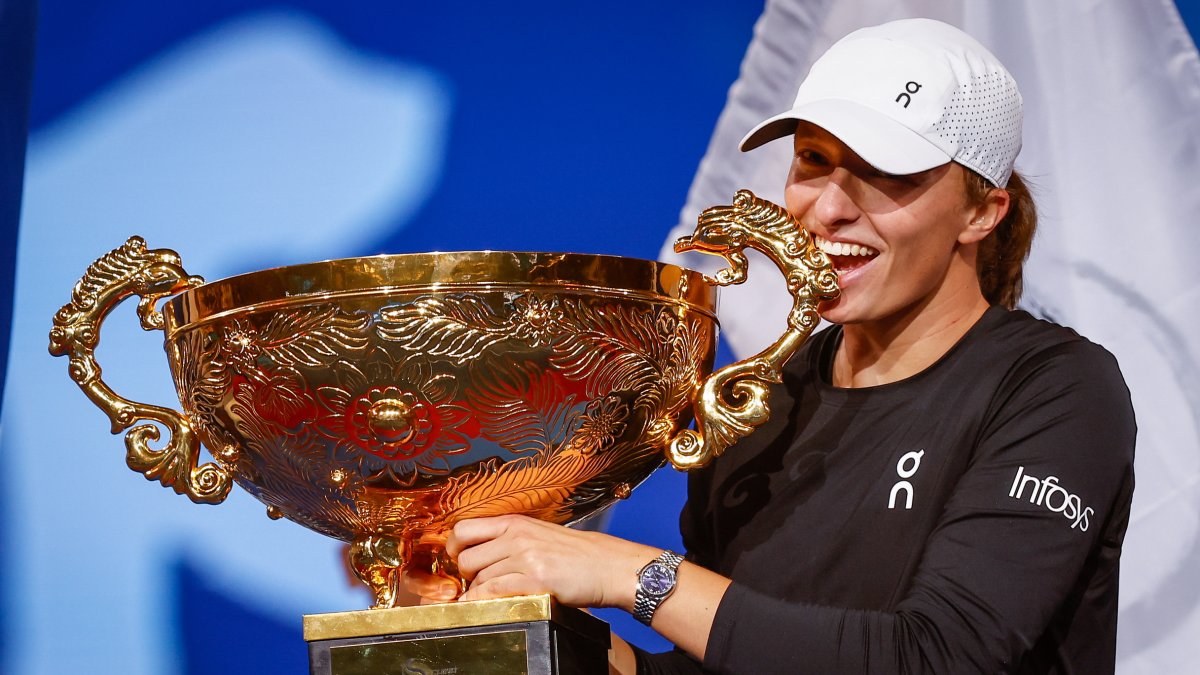 Iga Swiatek de Polonia muerde su trofeo después de ganar el partido final femenino de individuales contra Liudmila Samsonova de Rusia.