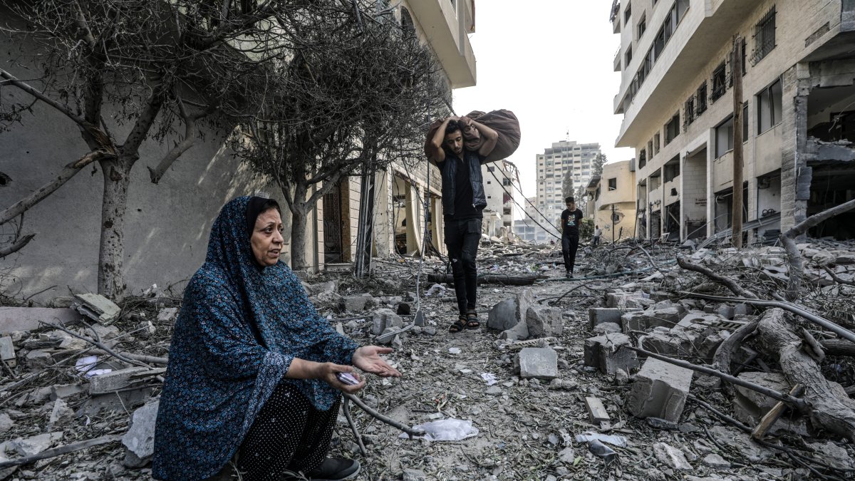 Una mujer palestina reacciona mientras inspeccionan los escombros de una zona destruida en el barrio de Al-Ramal, tras los ataques aéreos israelíes, en la ciudad de Gaza.