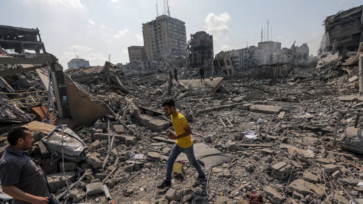 Palestinos caminan entre los escombros tras un ataque a la zona de Al-Ramal, tras un ataque israelí, este 10 de octubre de 2023 en la Ciudad de Gaza.