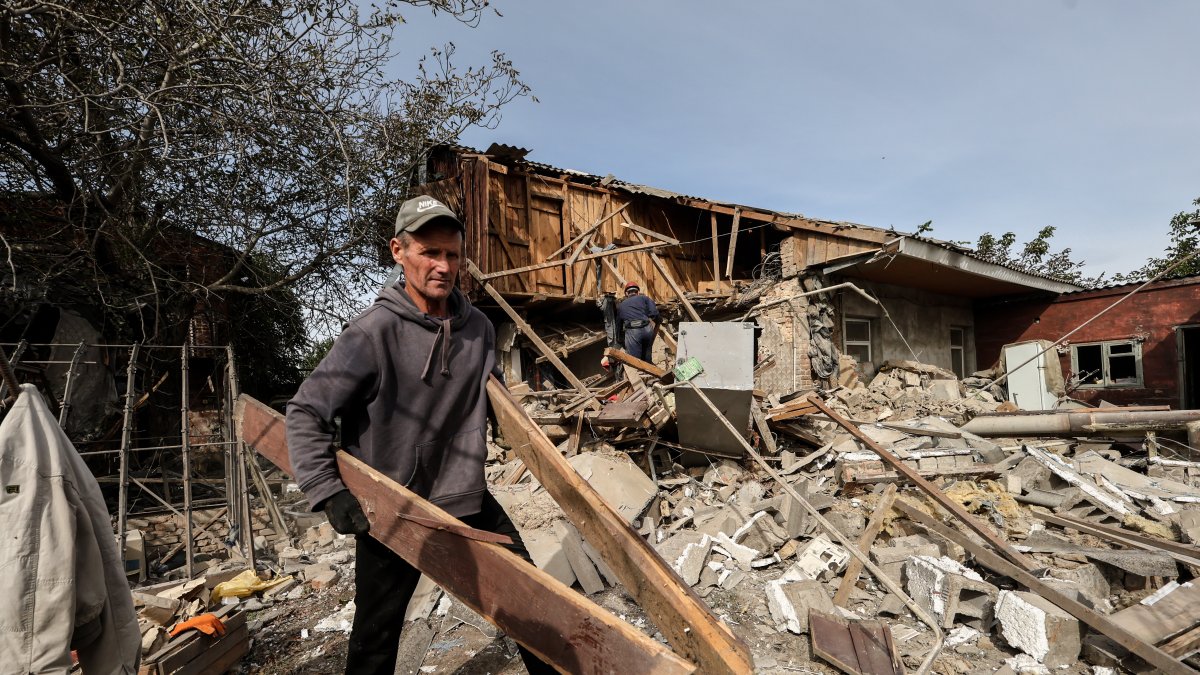 Un hombre limpia los escombros de una casa destruida después de un bombardeo en la aldea de Bilenke, región de Zaporizhia, Ucrania, 07 de octubre de 2023.