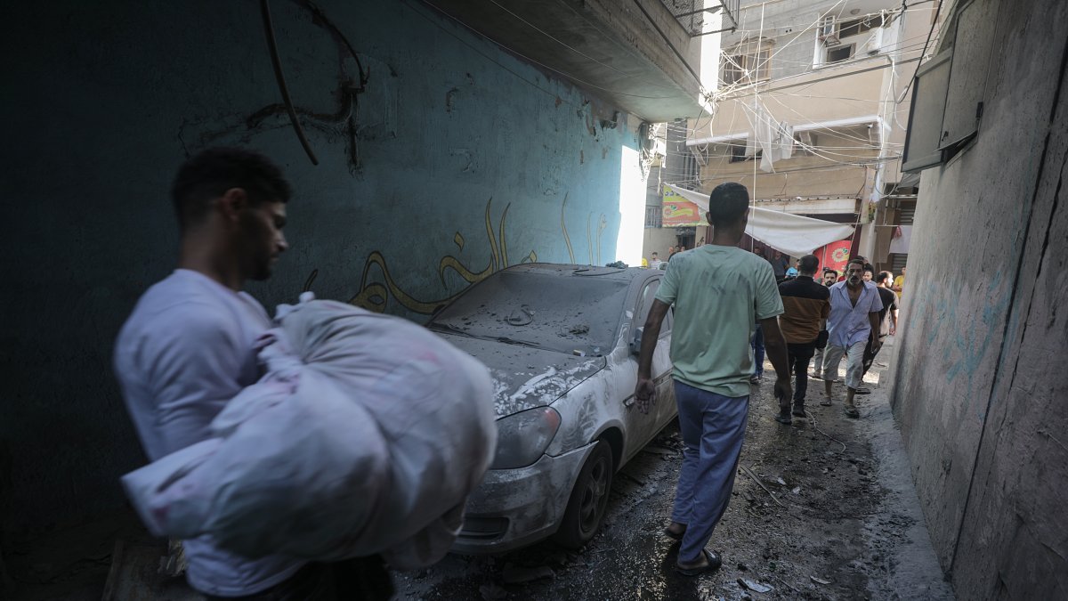 Un cuerpo es cargado del lugar del ataque aéreo de Israel en el campo de refugiados Shati en Gaza