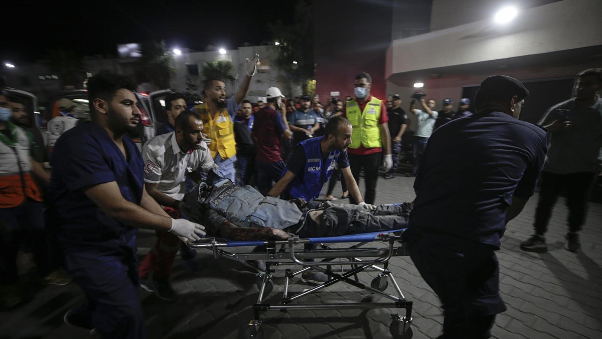 Vista de personas que llevan a un periodista palestino herido en Gaza, el 10 de octubre de 2023.