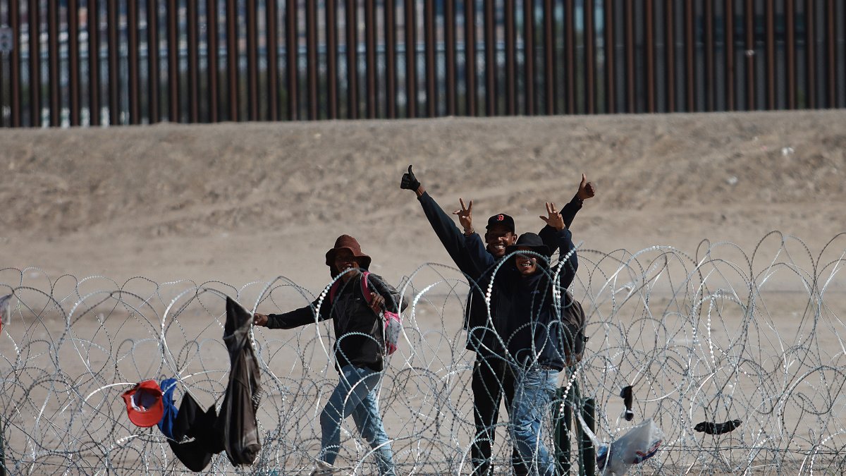 Espera. Un grupo de migrantes a un costado de la frontera.