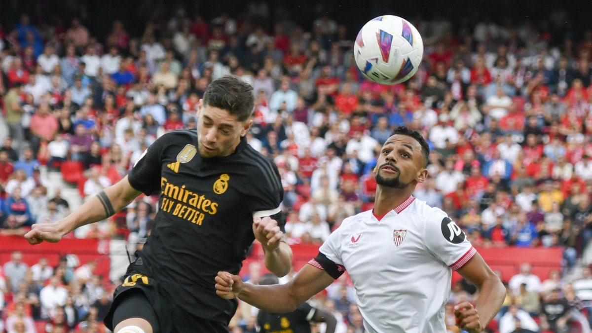 El centrocampista del Real Madrid Fede Valverde (i) cabecea un balón ante Djibril Sow, del Sevilla.