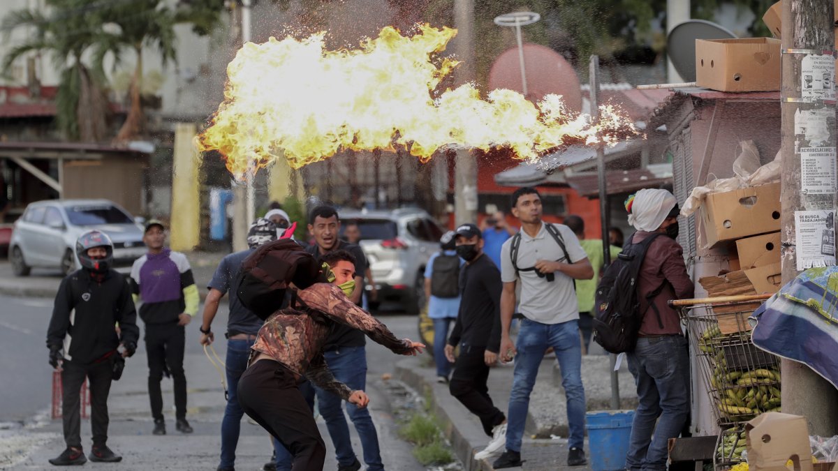 Manifestantes se enfrentan a la policía durante una protesta hoy, en las afueras de la Asamblea Nacional de Ciudad de Panamá (Panamá).