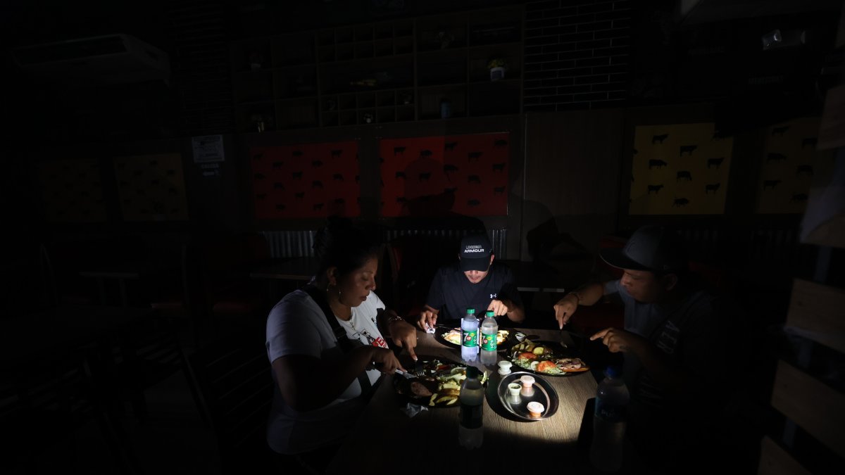 Restaurante. En Guayaquil, en la avenida 9 de Octubre, las personas  almuerzan a la luz de los celulares. En esta zona el corte de energía eléctrica ayer fue de 11:00 a 14:00.
