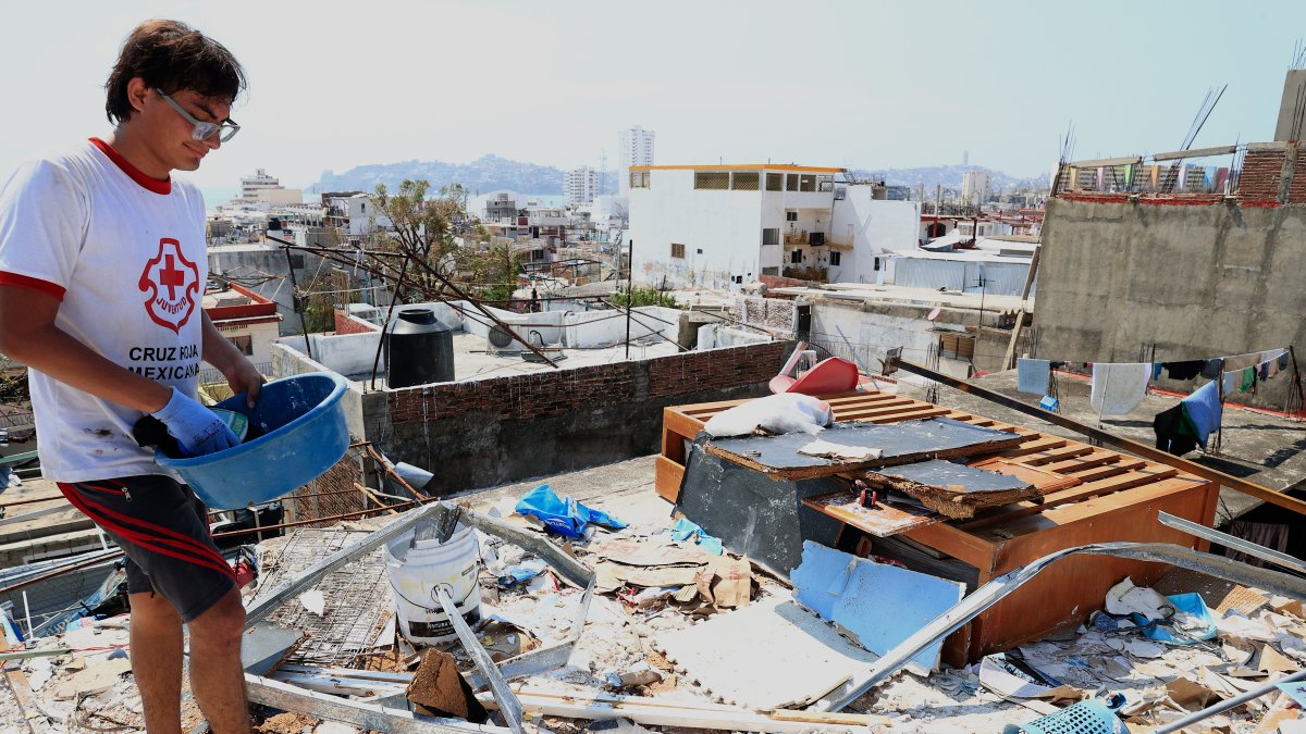 Una persona limpia su casa hoy, en una zona afectada por el paso del huracán Otis, en el balneario de Acapulco, en el estado de Guerrero (México).