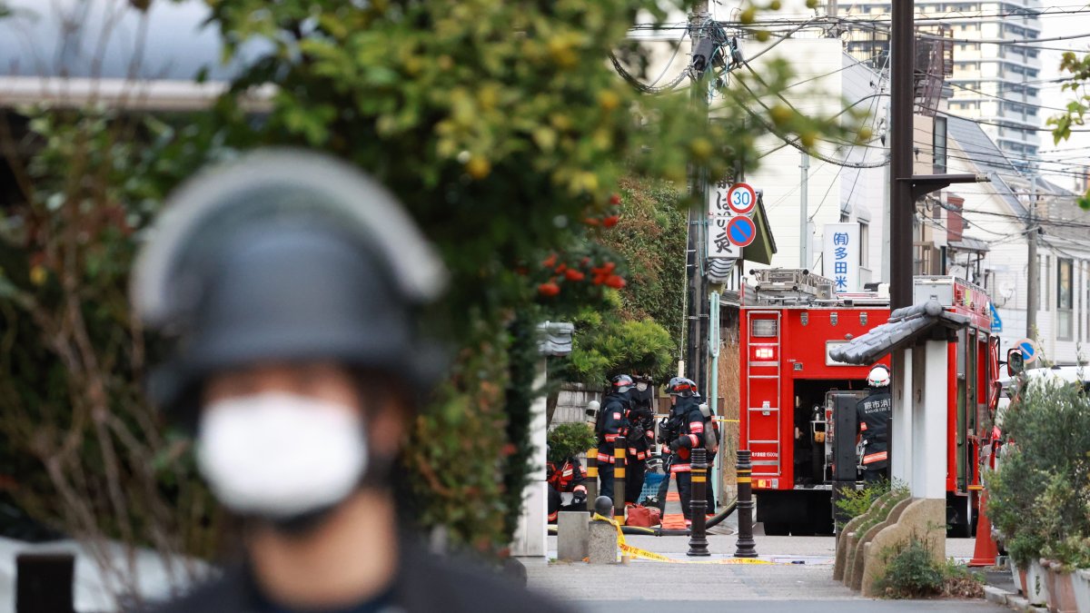 Agentes de policía y del servicio de rescate trabajan en el área crcana de la oficina de correos donde una persona tomó rehenes y se atrincheró en la ciudad de Warabi.