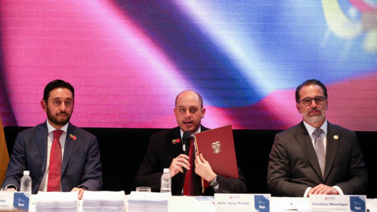 El exministro de Producción, Comercio Exterior, Inversiones y Pesca de Ecuador, Julio José Prado (c) y el actual ministro, Daniel Legarda, durante la firma del acuerdo comercial con China.