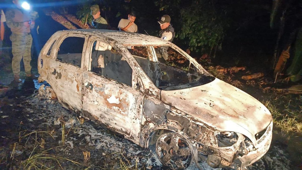 Escena. La policía busca indicios para saber quiénes eran las personas quemadas en la cajuela de un carro.