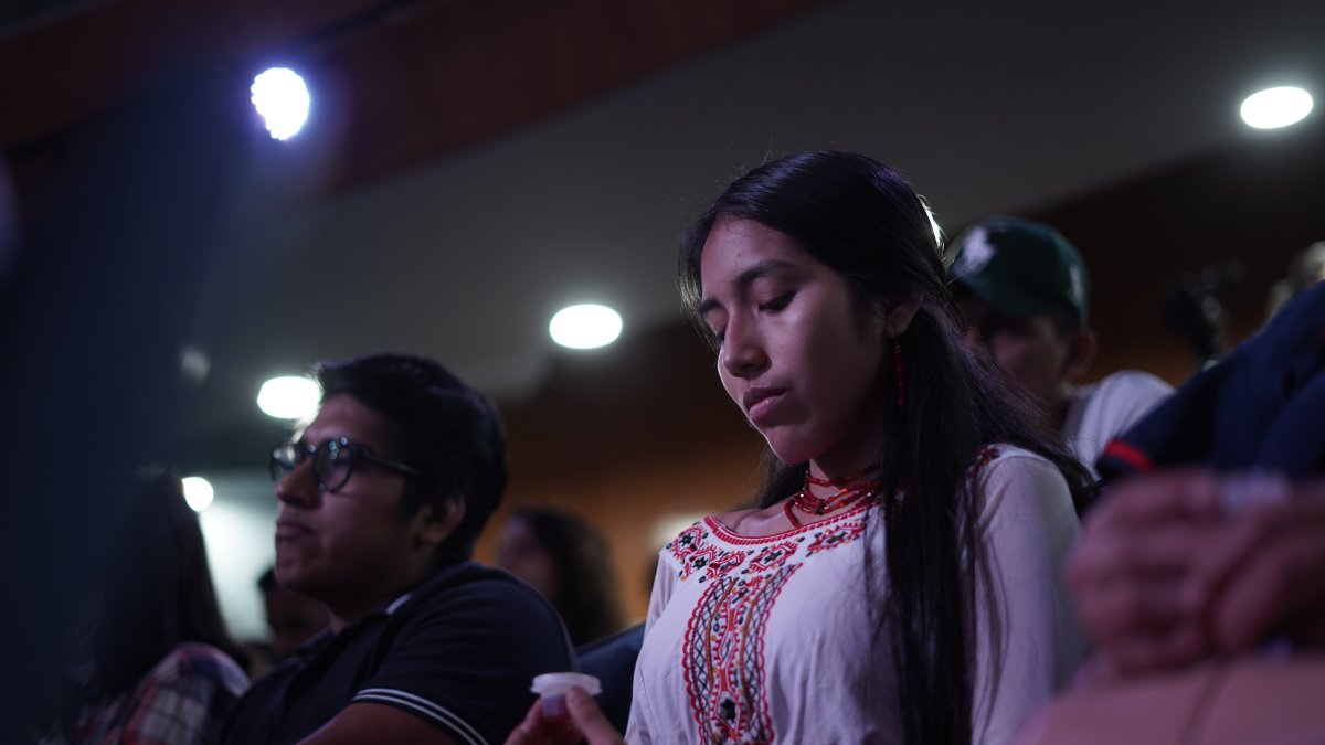 Una mujer indígena acude a una iglesia cristiana en Guayaquil junto a un alimento propio de la cultura