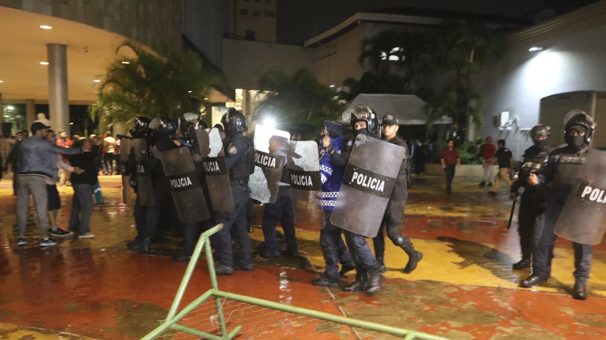 Miembros de la Policía se enfrentan con simpatizantes del gobernante Partido Libertad y Refundación (Libre) hoy, en el Congreso Nacional en Tegucigalpa (Honduras).