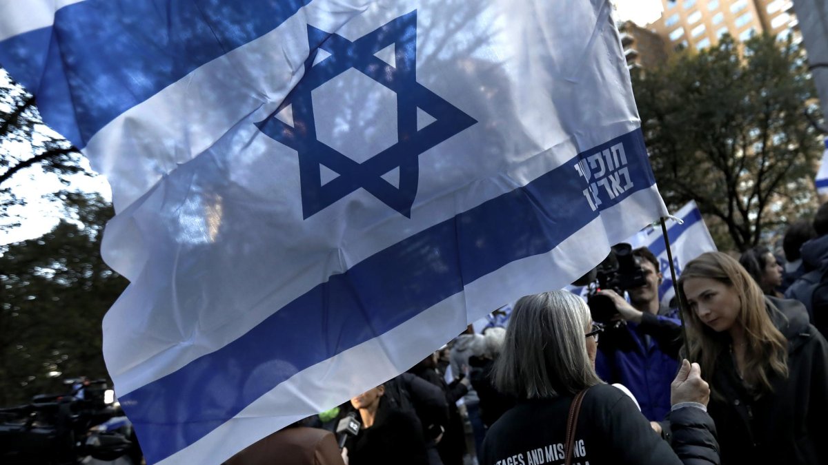 Una mujer sostiene una bandera israelí durante una vigilia con velas para las víctimas israelíes en Nueva York, Nueva York, EE.UU., 01 de noviembre de 2023.