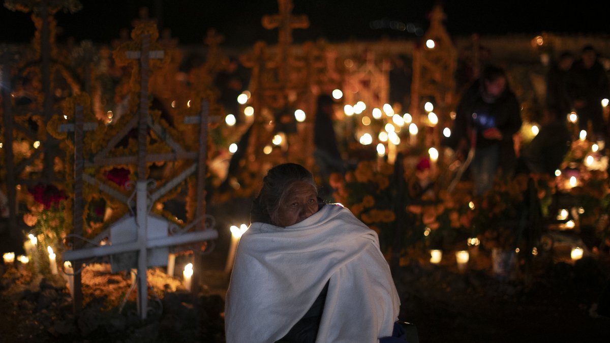 Familias se reúnen alrededor de las tumbas de sus seres queridos en Pátzcuaro, estado de Michoacán (México).