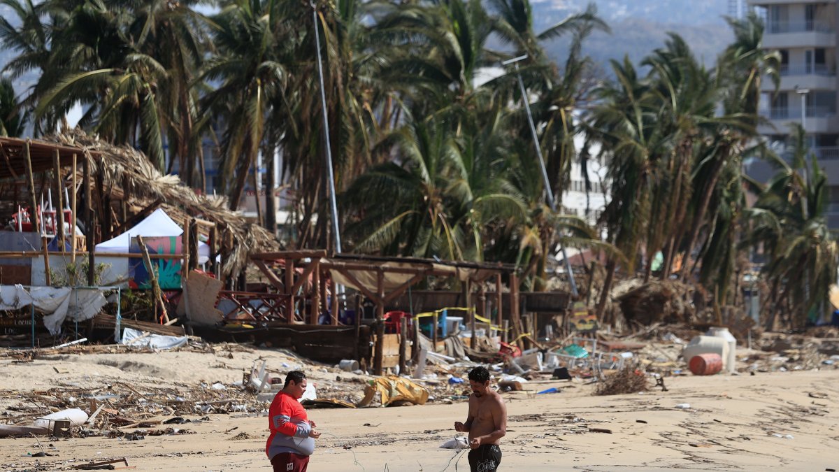 Personas permanecen un una de zonas afectadas por el paso del huracán Otis en el balneario de Acapulco, en el estado de Guerrero (México).