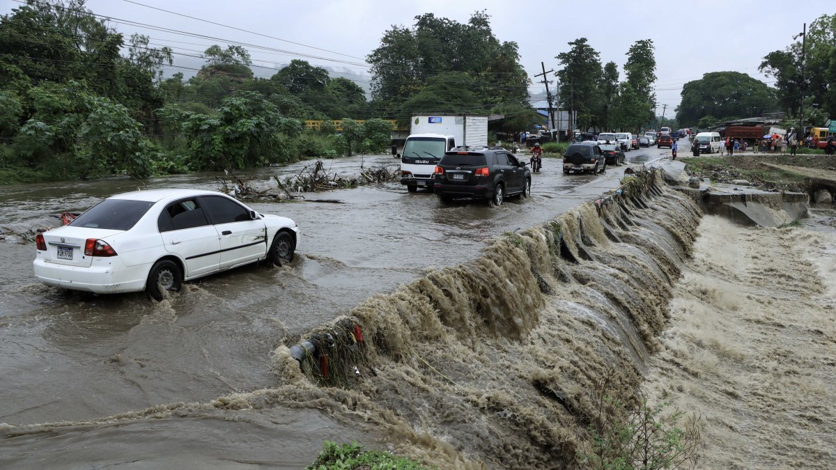 Tegucigalpa. Varios vehículos transitan por una carretera afectada por la creciente de agua en una quebrada.
