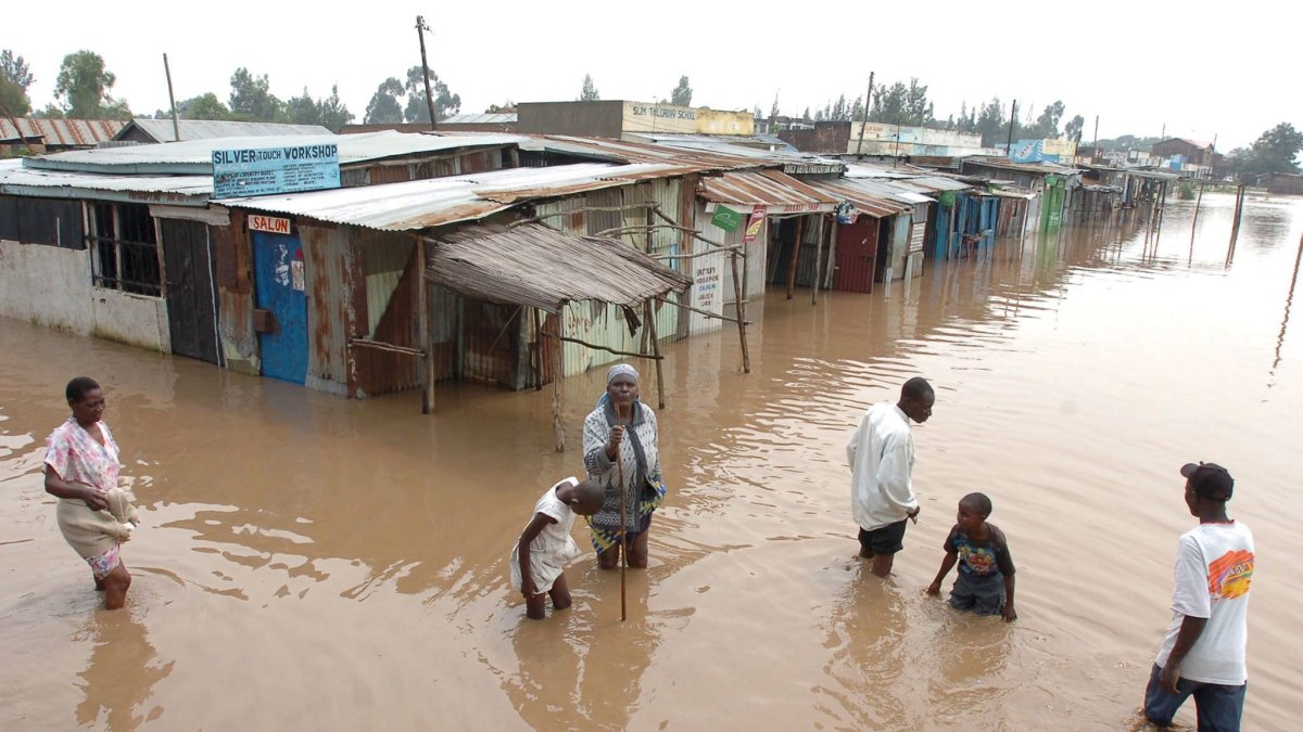 La gente camina por una calle inundada en una ciudad cerca de Nairobi, la capital de Kenia.
