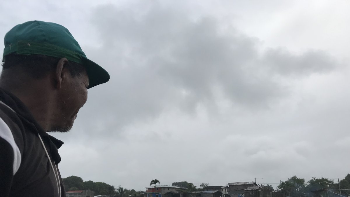 Uno de loas habitantes del Cauchal observa desde lejos el caserío al pie del mar.