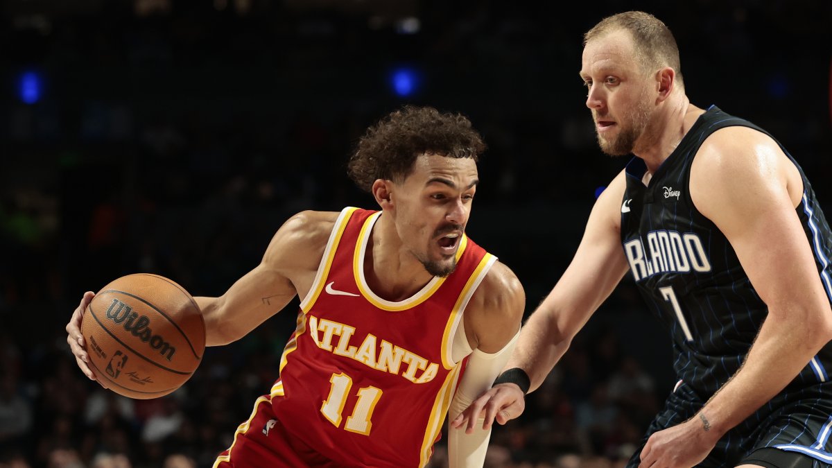 Joe Ingles (d), de Orlando Magic, disputa el balón con Trae Young, de Atlanta Hawks, durante un juego de la NBA en la Arena Ciudad de México.