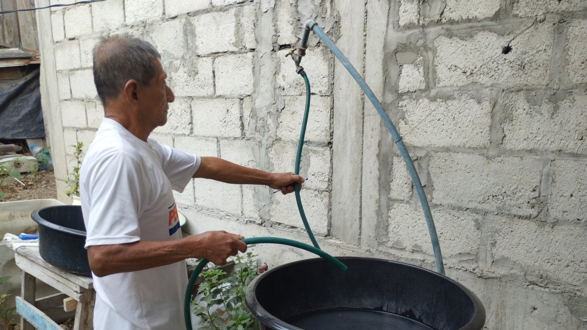Una persona se aprovisiona de agua ante el anuncio de suspender el servicio de manera imprevista en la península de Santa Elena.