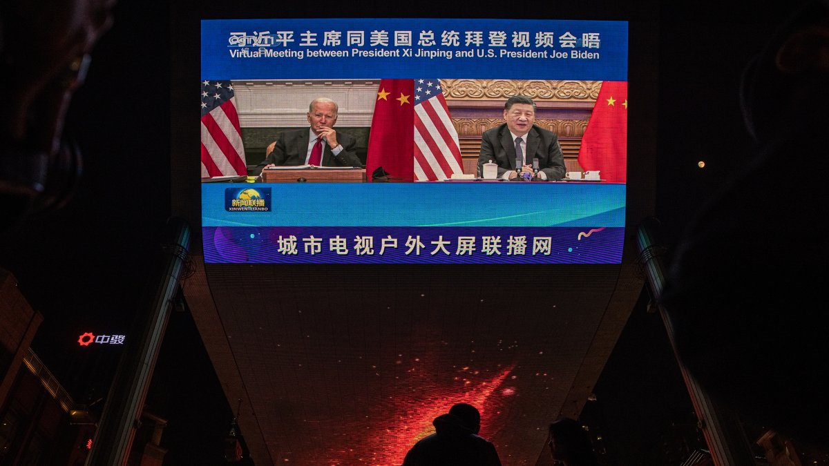 Imagen de archivo de una pantalla grande que muestra al presidente estadounidense Joe Biden (izq) y al presidente chino Xi Jinping.