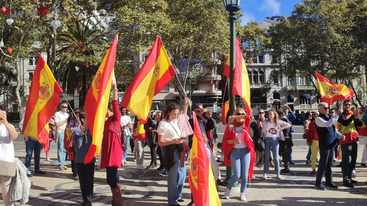 Un grupo de personas protesta, bandera en mano, este domingo contra la amnistía frente a la Embajada de España en Lisboa.