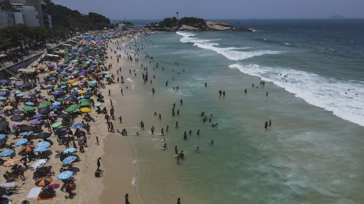 Fotografía aérea que muestra a miles de bañistas en la playa de Ipanema cuando se espera que la ciudad viva el día con más calor del año hoy, en Río de Janeiro (Brasil)