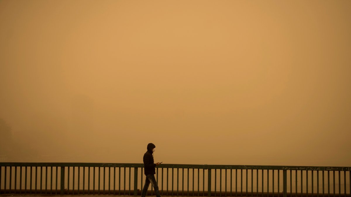 Un hombre sale a caminar durante una tormenta de arena en El Cairo, Egipto.