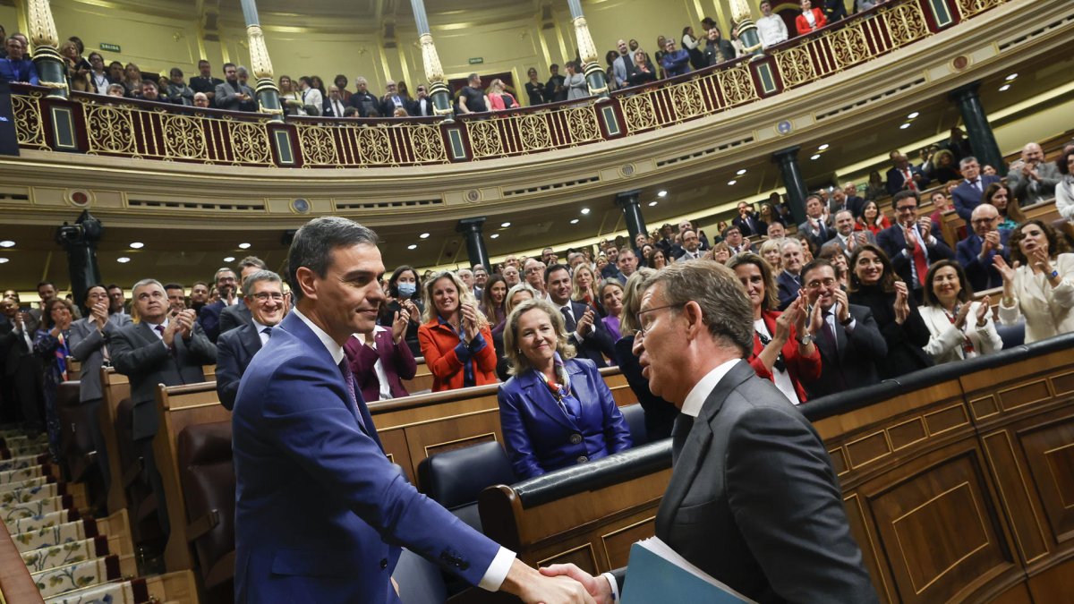 El líder del PP, Alberto Núñez Feijóo (d), felicita al presidente del Gobierno en funciones, Pedro Sánchez, al término de la segunda jornada del debate de investidura.