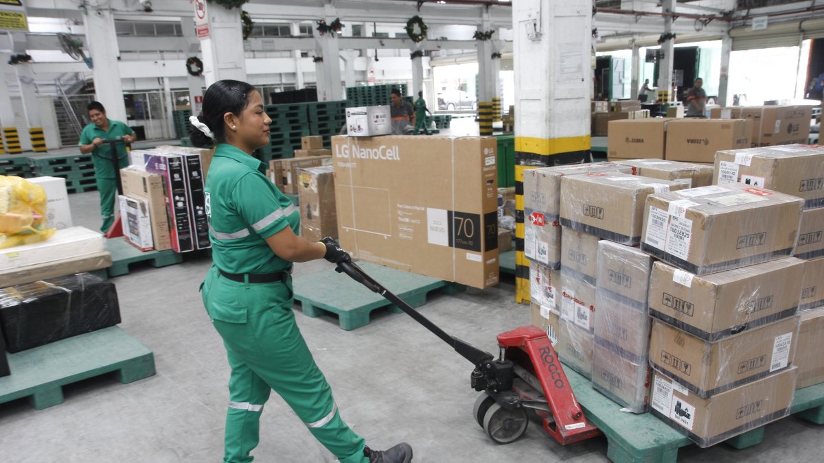 Trabajo.- Una mujer mueve la carga en Servientrega.